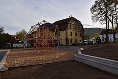 Das Bild zeigt den neuen Schulhof mit dem großen Klettergerüst. 