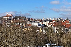 Das Bild zeigt einen Blick über die Innenstadt. Im Vordergrund sind Häuser, im Hintergrund sieht man den Frauenberg und den Aschenberg.