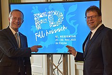 Staatsminister Axel Wintermeyer und Oberbürgermeister Dr. Heiko Wingenfeld zeigen das Logo für den Hessentag 2021.