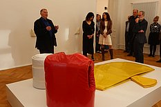 Das Bild zeigt Franz Erhard Walther wie er einigen Gästen seine Kunstwerke erklärt.